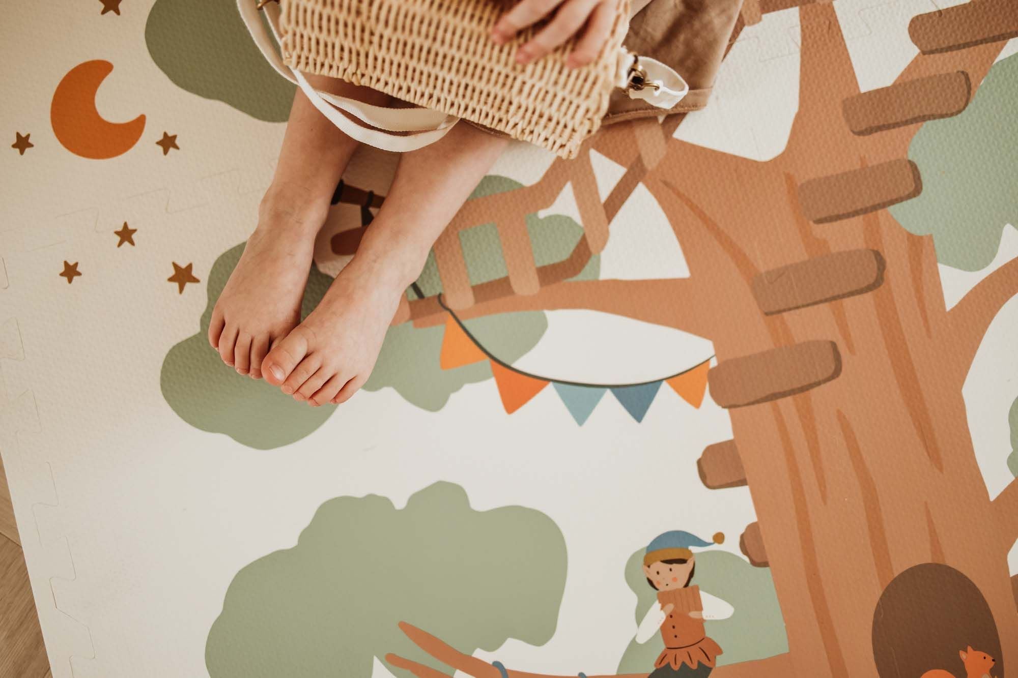 EEVAA Treehouse puzzlemat, close picture, child is sitting on the mat, little feet and wooden basket