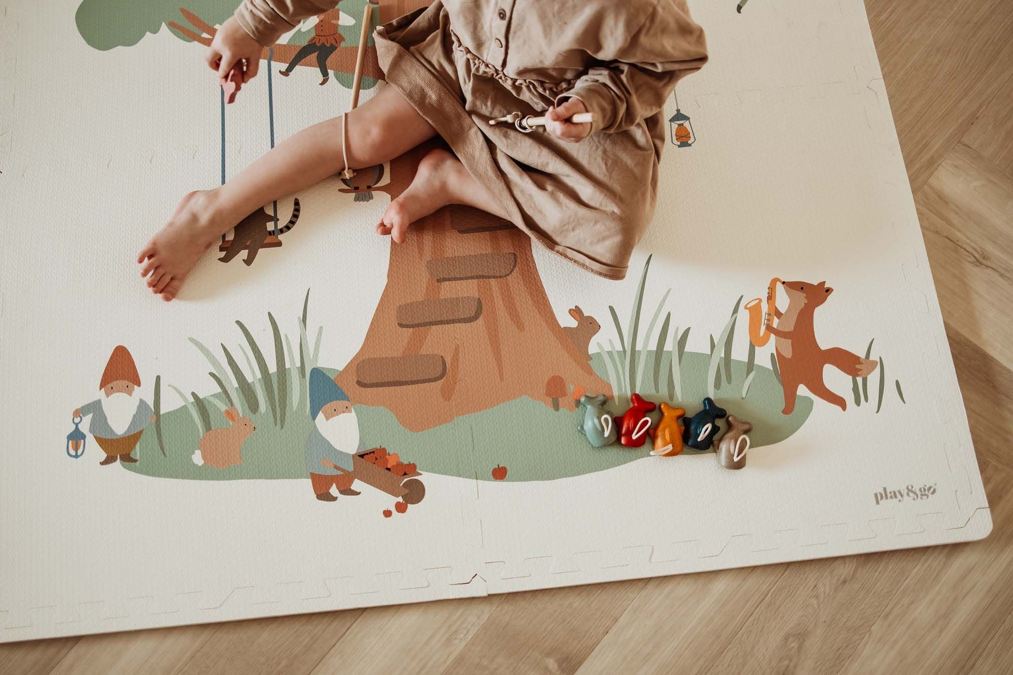 EEVAA Treehouse puzzlemat, child is playing on the mat, gnomes and rabbits, a fox playing the music