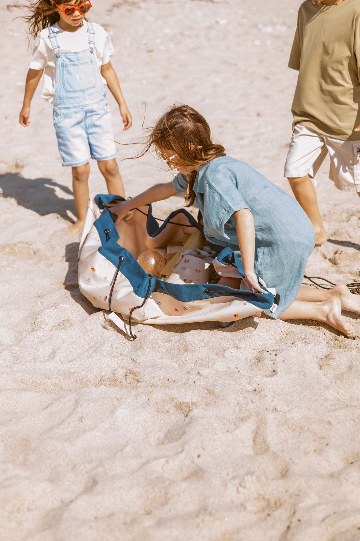 magical days outdoor beach bag, children are opening the bag in the sand at the beach