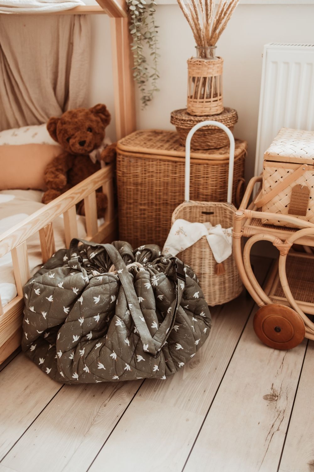 birds soft organic babymat, closed, standing next to a wooden bed and wooden and baskets
