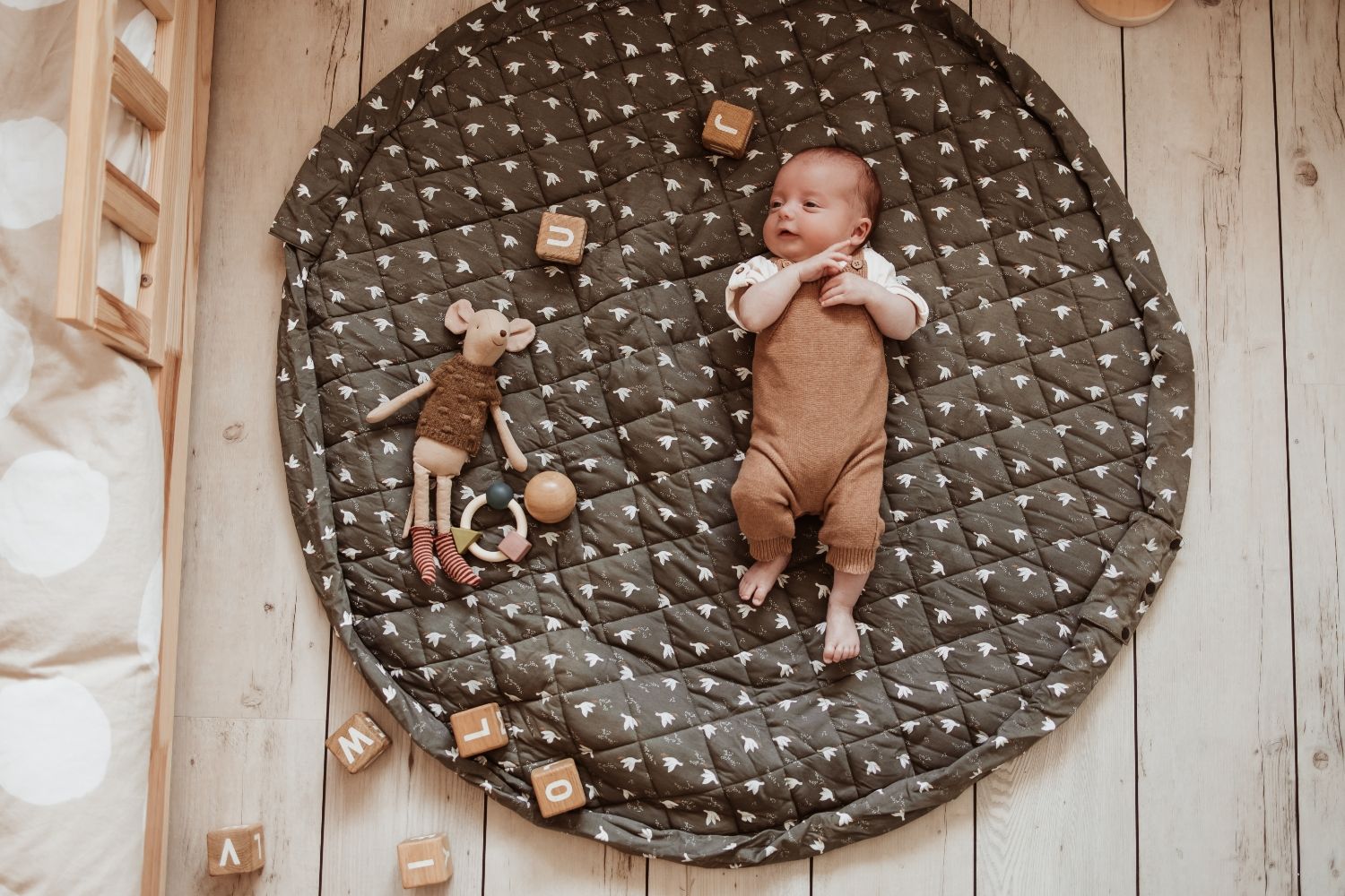 birds soft organic babymat, open on floor in kidsroom, baby is lying on the mat, wooden blocks and mouse cuddle