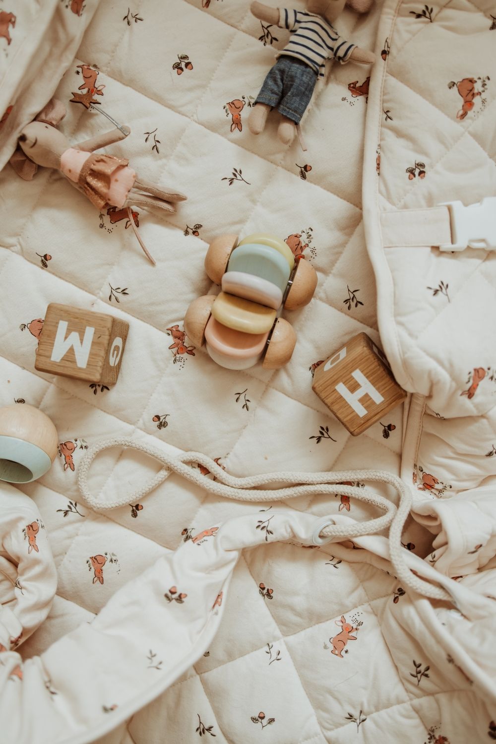 detail of rabbit soft organic babymat, cuddles and wooden blocks, wrope to close the bag