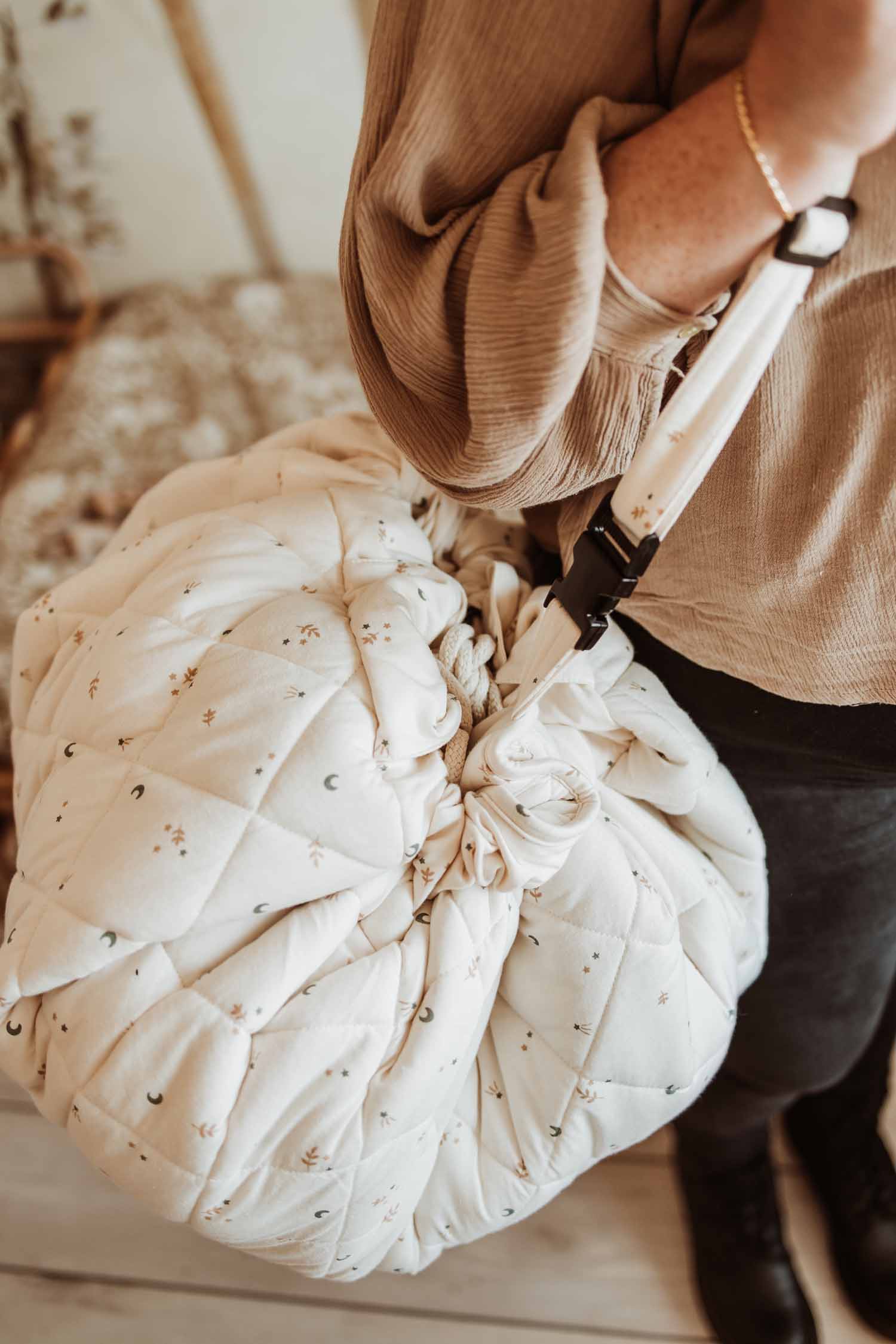 Moon organic babymat, person carrying the closed bag with a shoulder strap