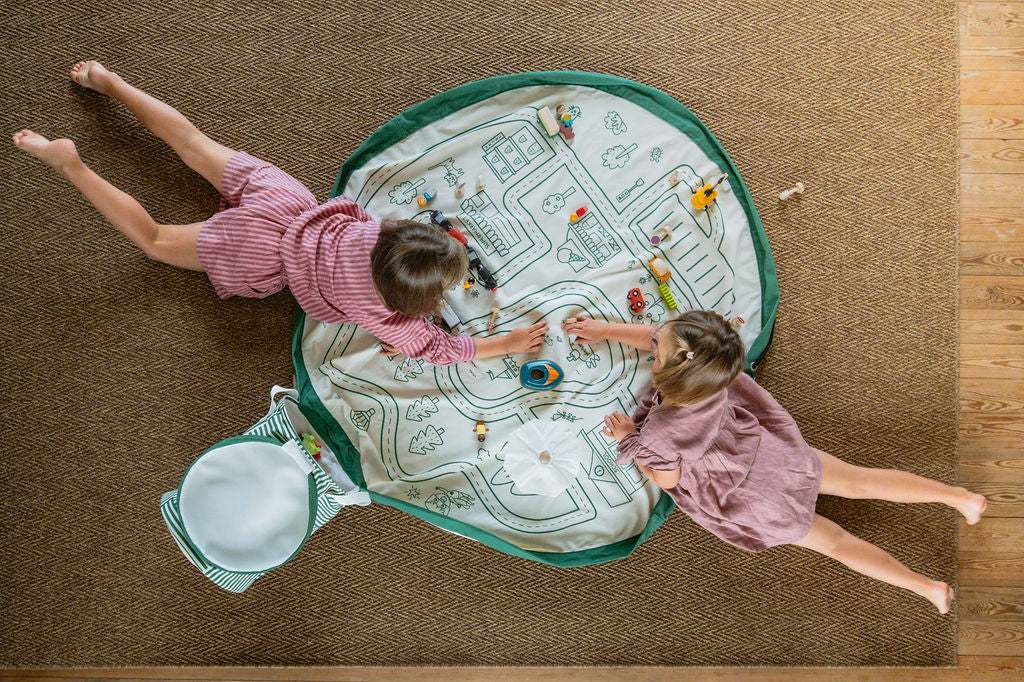 soo roadmap, open basket and open mat on carpet, children are lying down while playing with wooden toys