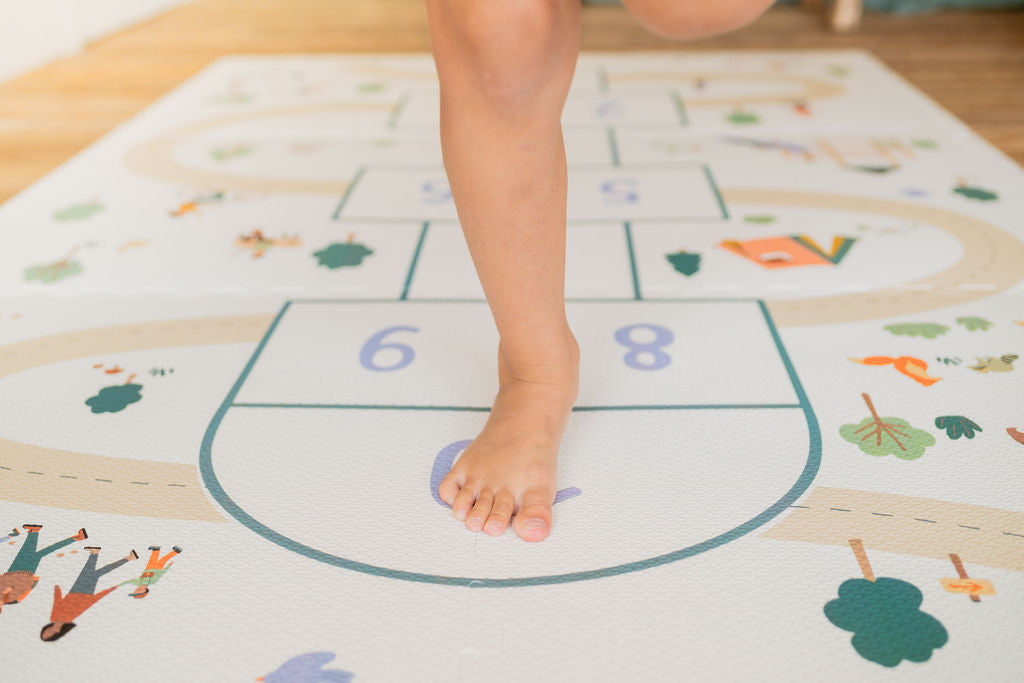 tiloo hopscotch, child is playing on the mat, jumping with one leg
