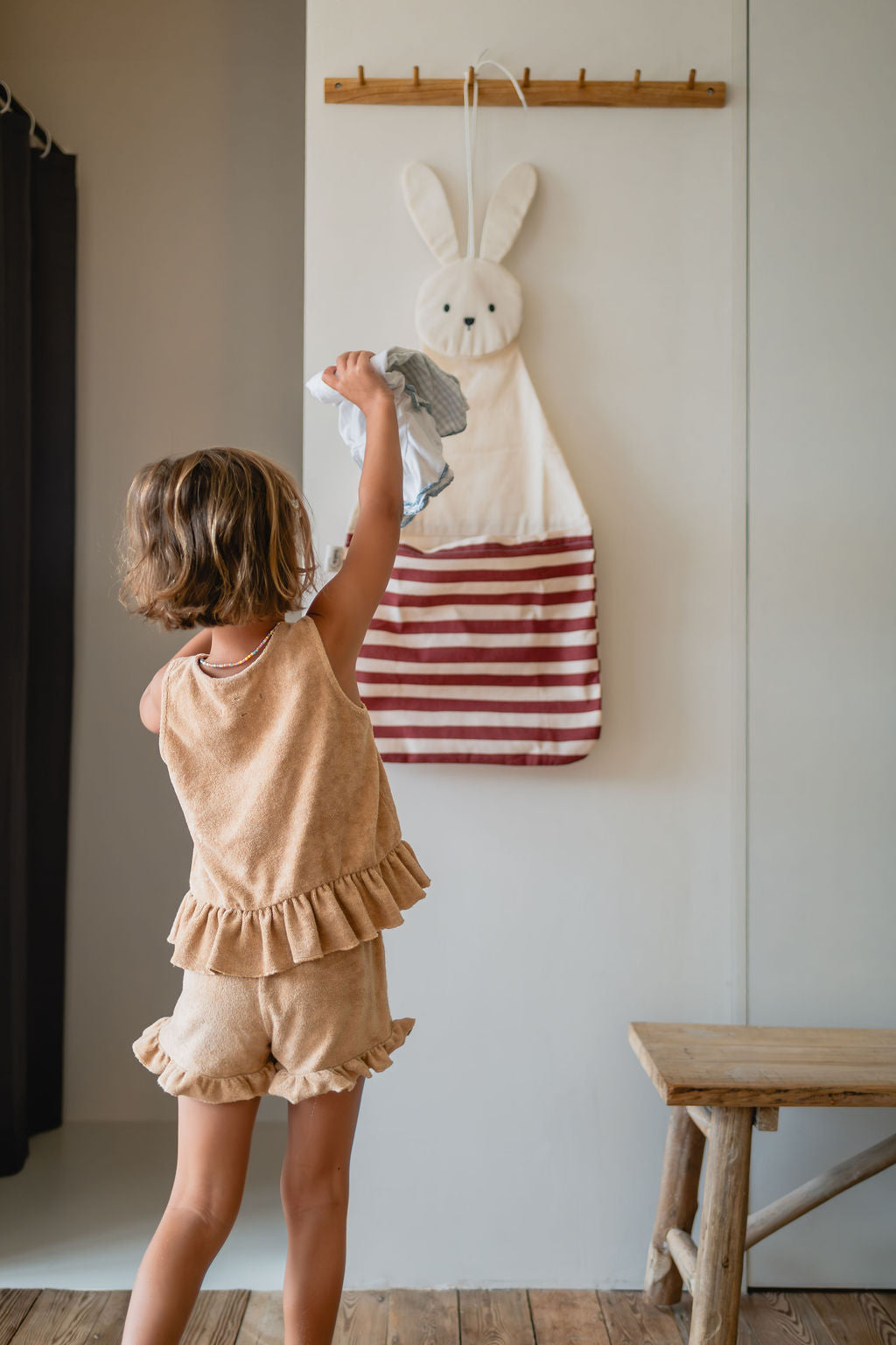 toto bunny, hanging on coat rack, child is putting its pyjamas into the bag