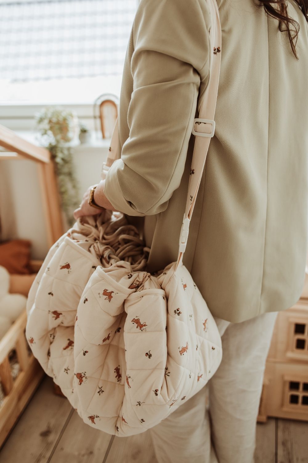 rabbit soft organic babymat, person is carrying the closed bag with the shoulder strap