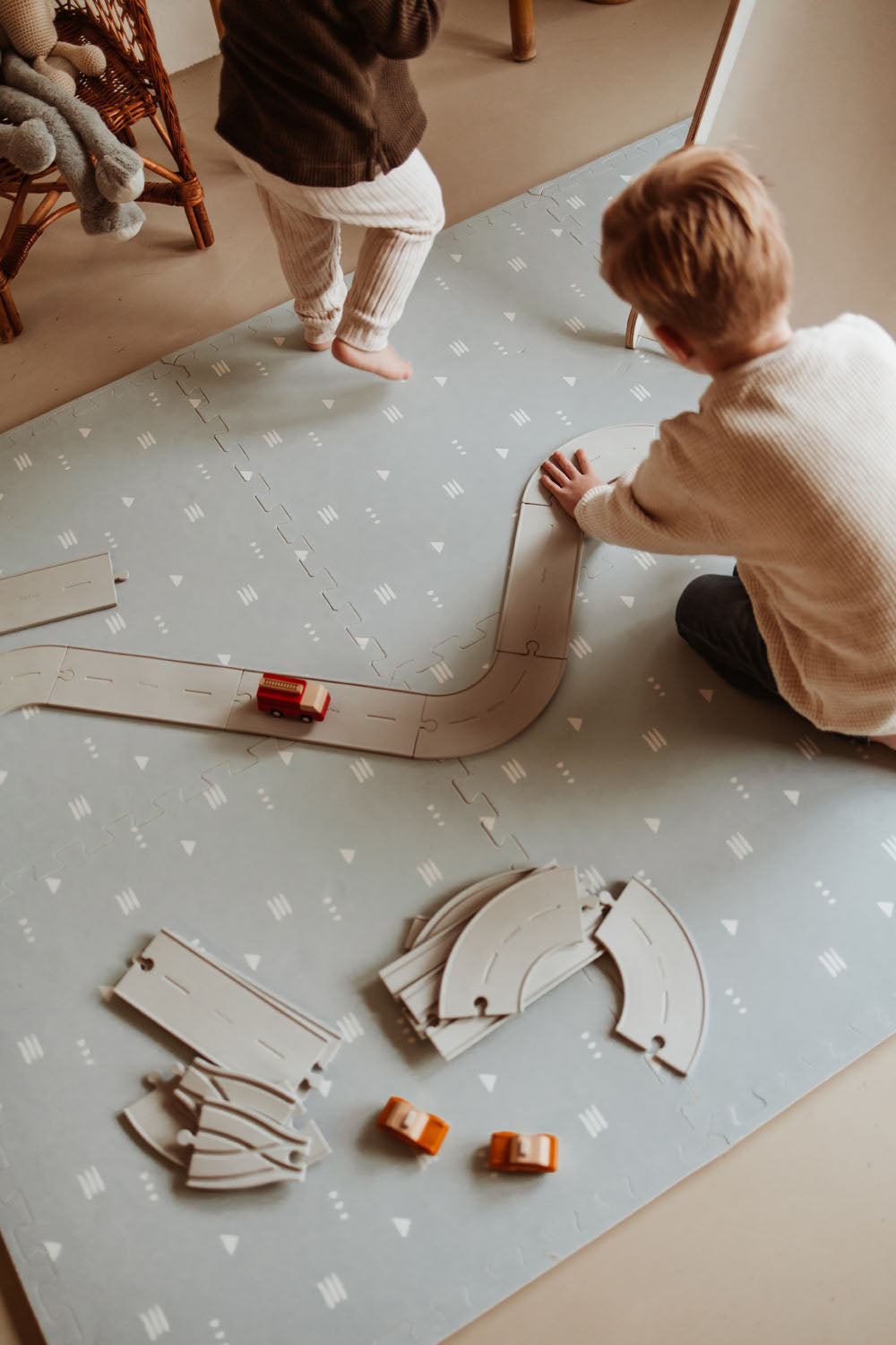 children playing with road and wooden toys on icons puzzlemat