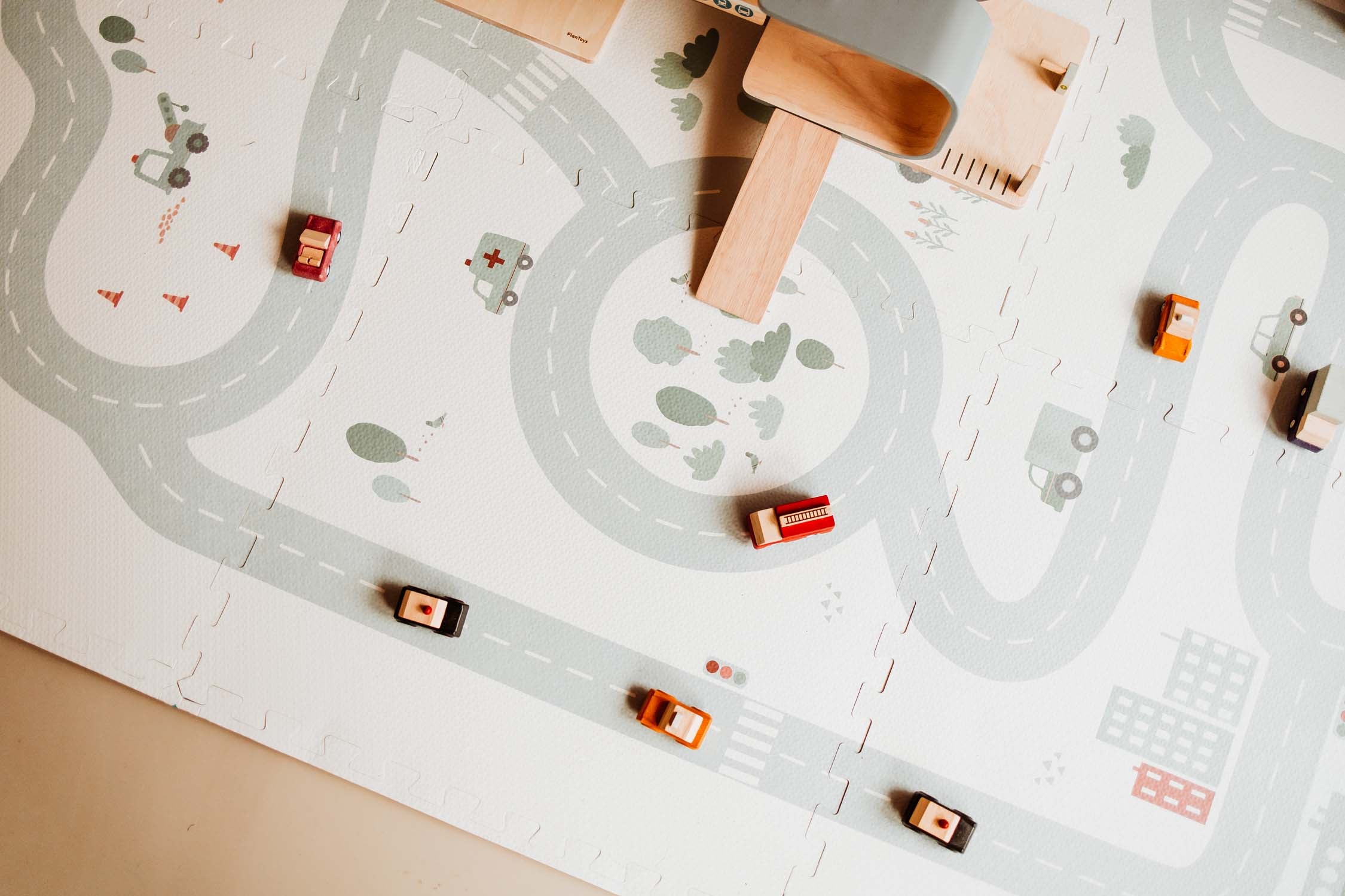 wooden cars and wooden garage on roadmap puzzlemat