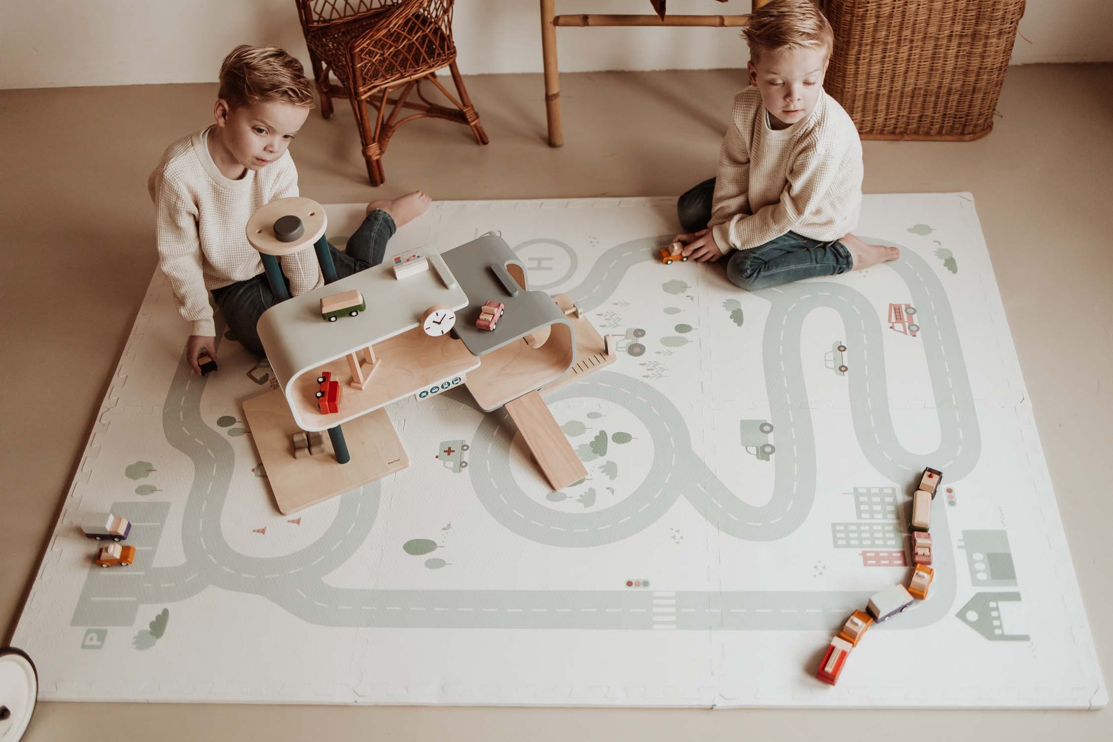 children playing with wooden garage on roadmap puzzlemat in kidsroom