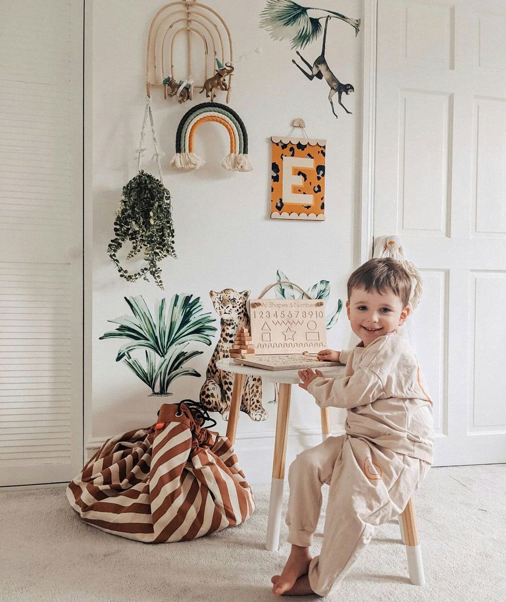 Play&Go toystorage bag and play mat, bag on floor, next to wall and little table, child playing