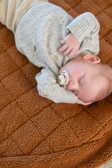 noomad soft teddy brown, baby is sleeping on the open mat
