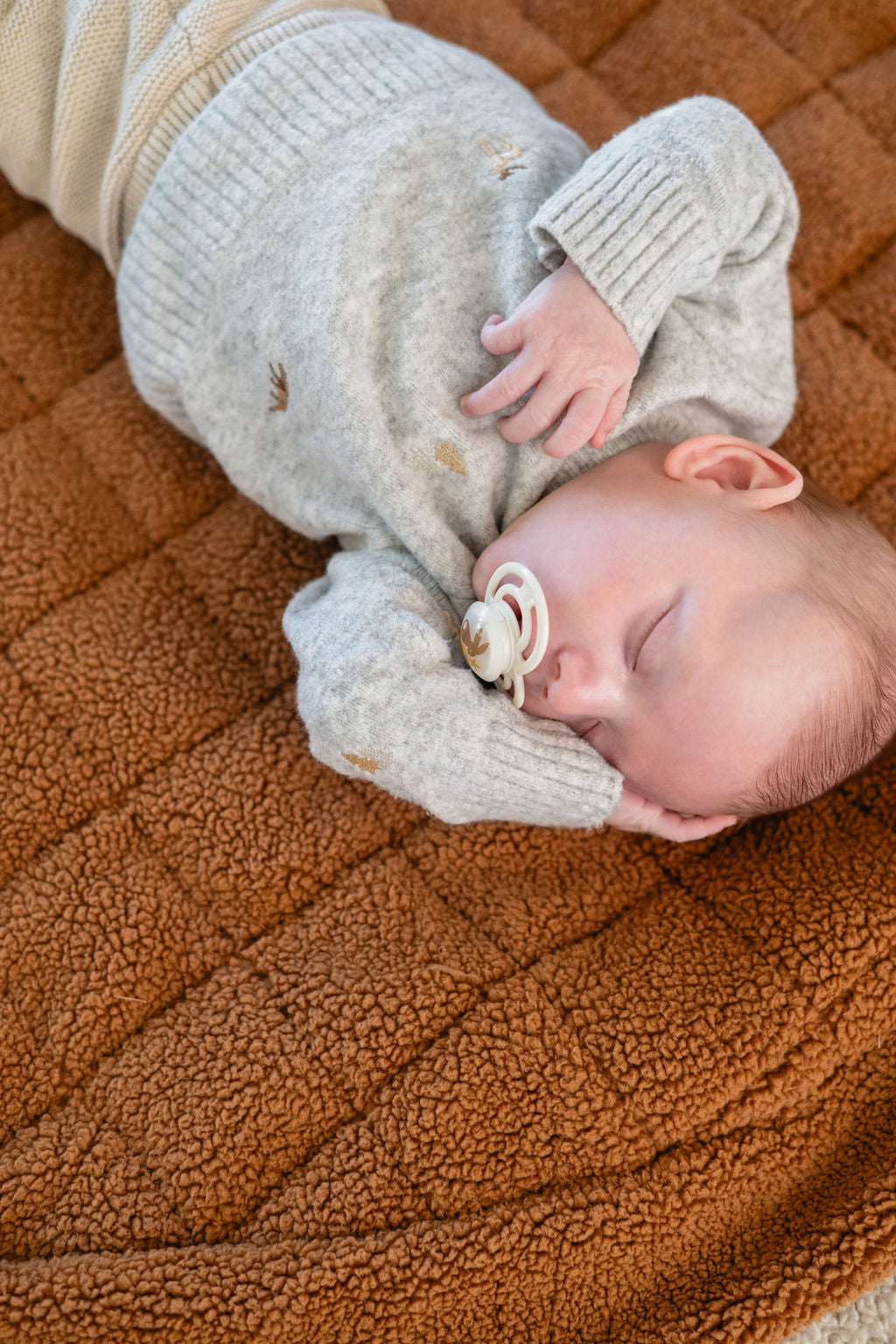 noomad soft teddy brown, baby is sleeping on the open mat