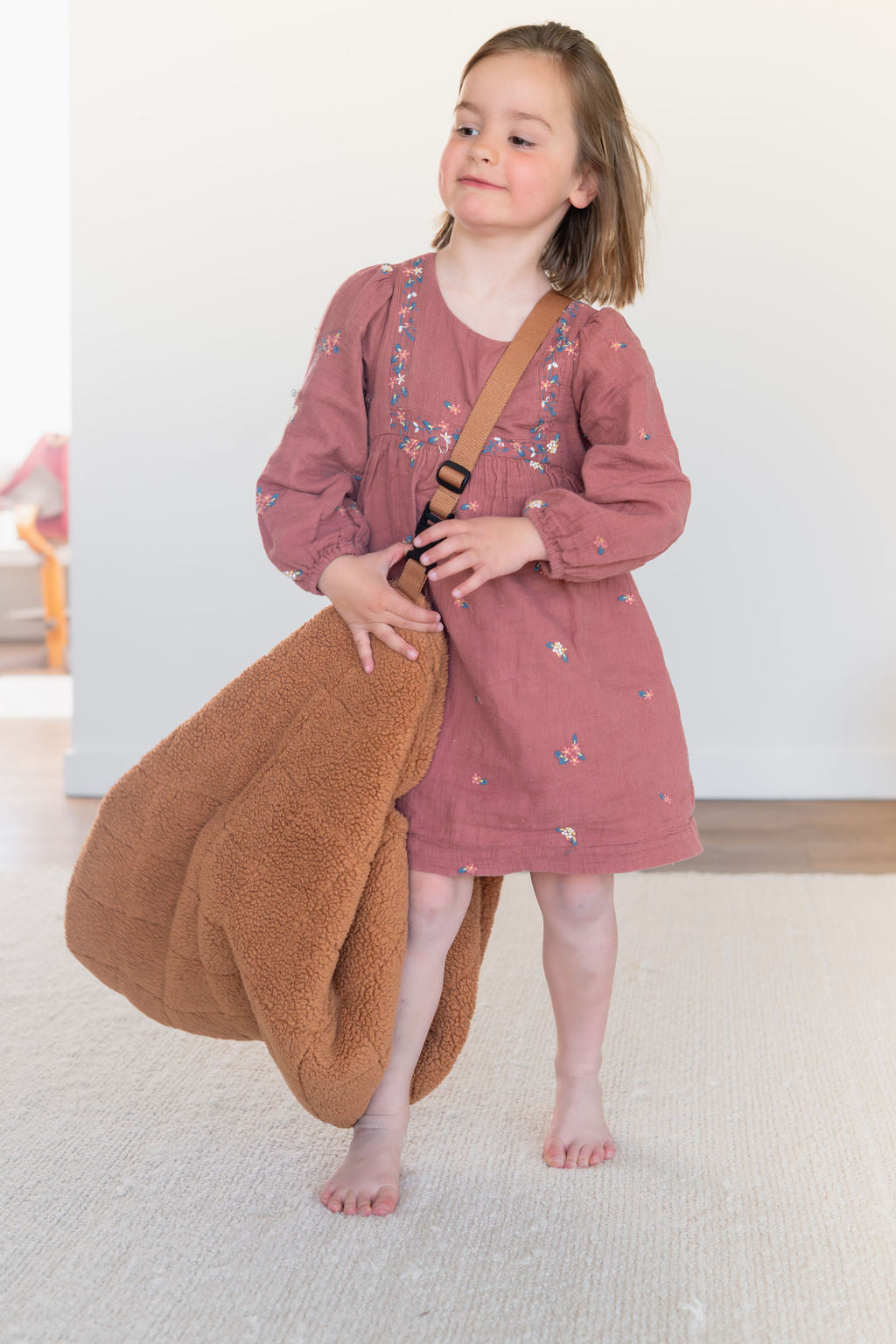 noomad soft teddy brown, child is carrying the closed bag