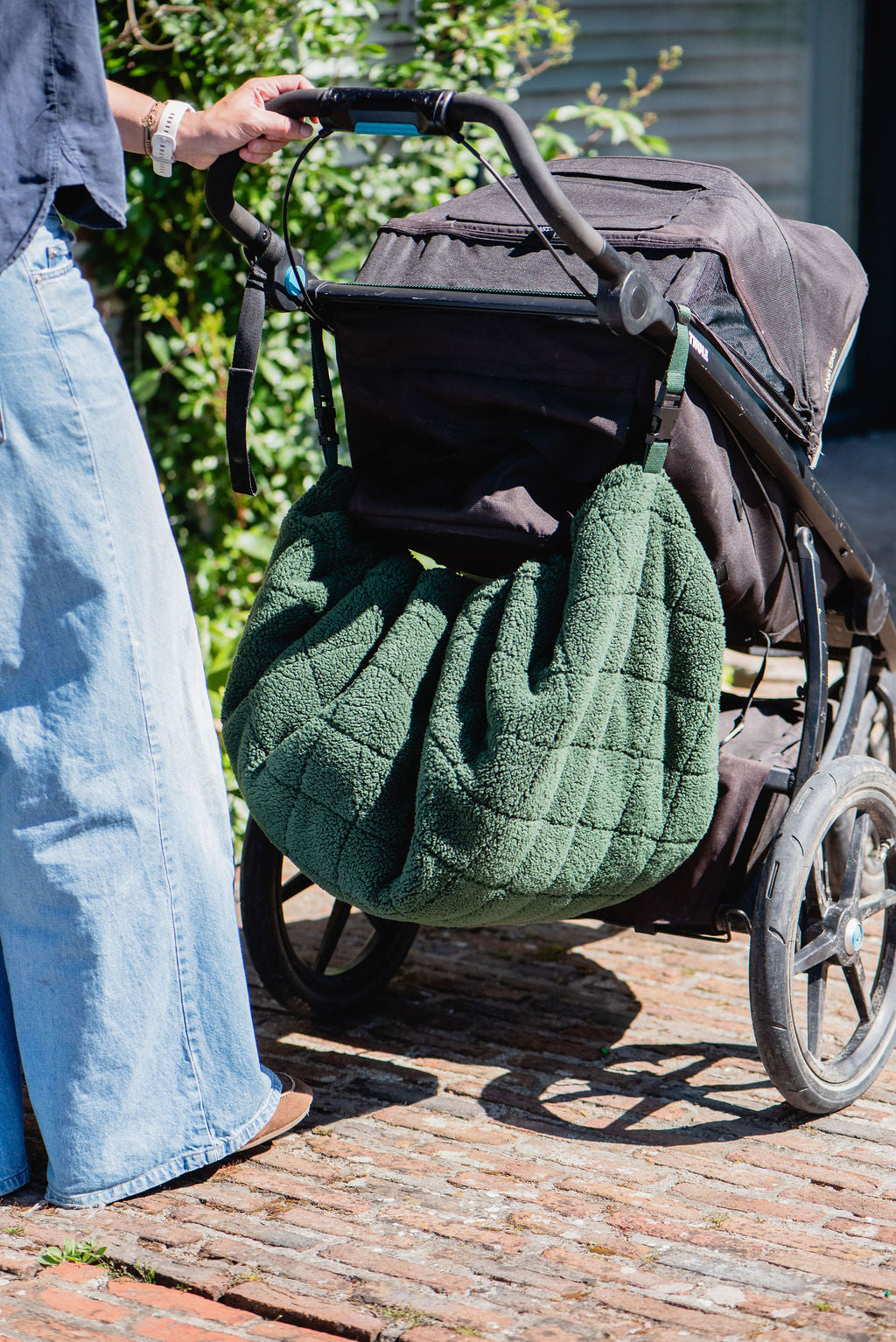 noomad soft teddy evergreen, closed bag is hanging on the stroller