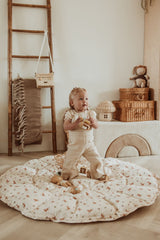 bloom rabbit babymat, open on floor in kidsroom, child is standing on the mat while playing with wooden toys