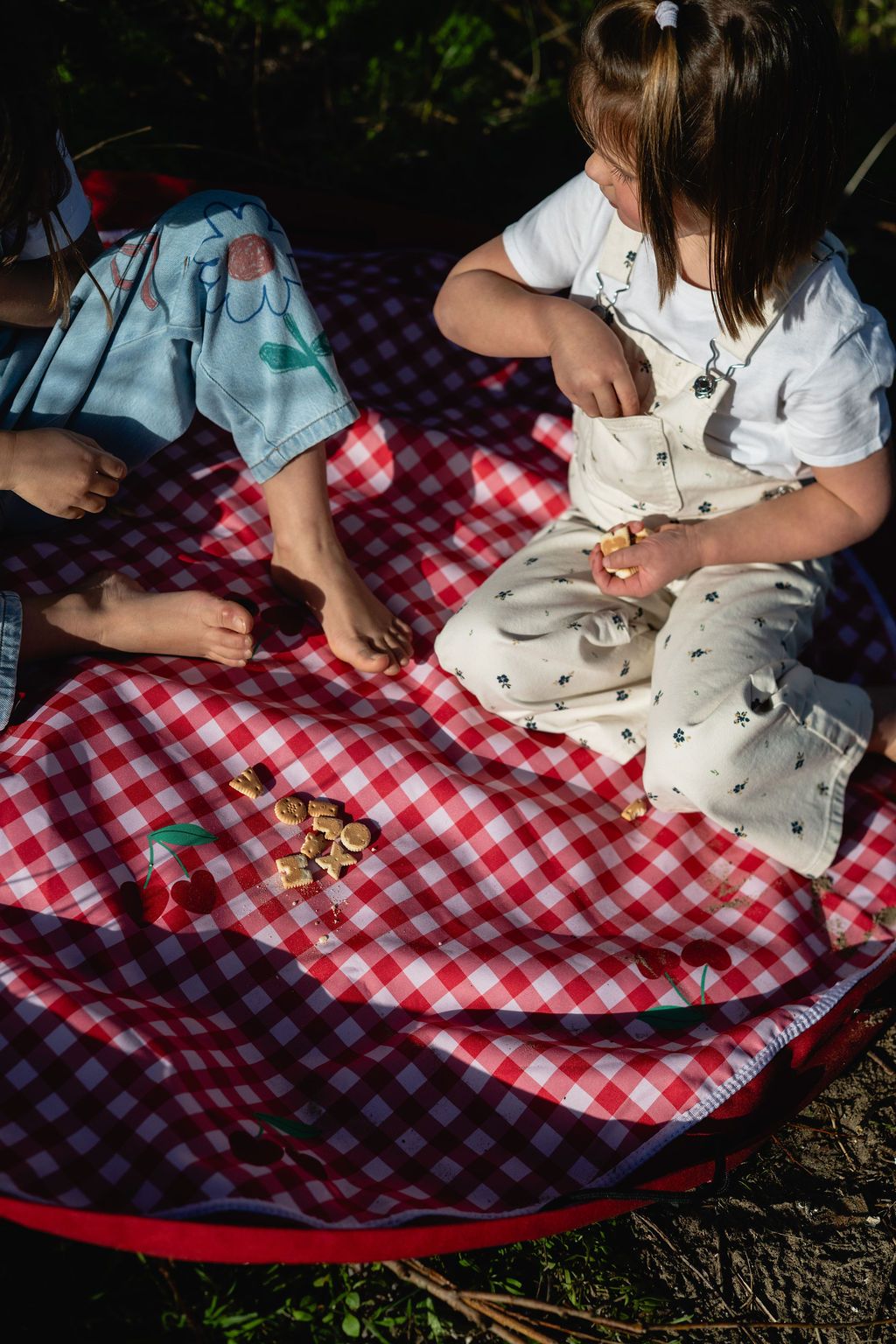 pic nic outdoor playmat, children are sitting on the mat outside, eating cookies