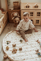 rabbit soft organic babymat, open on floor in kidsroom, child is playing with wooden toys, mouse cuddles, victorian playhouse