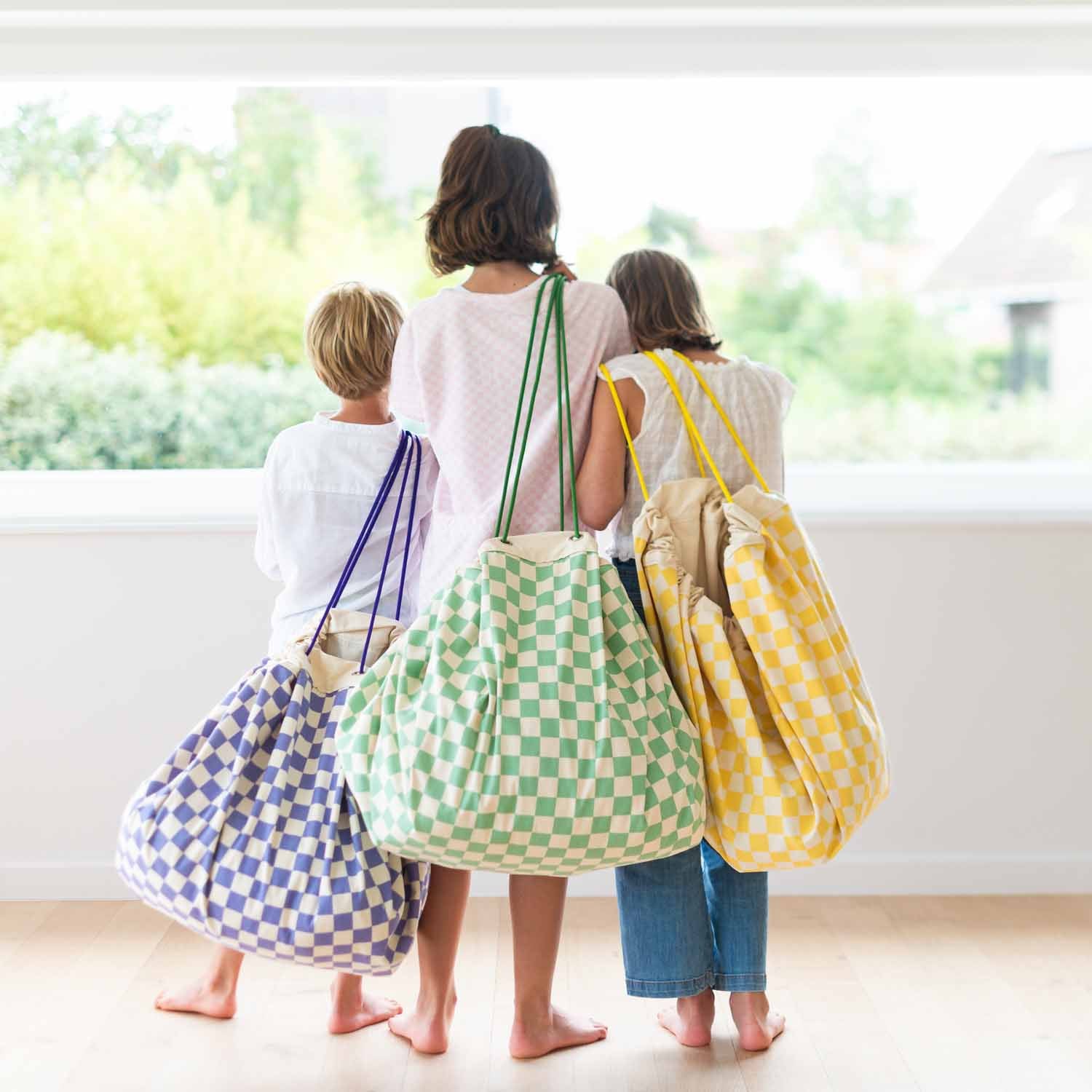 vichy toy storage bags, all colors, childres are carrying the bags while looking outside