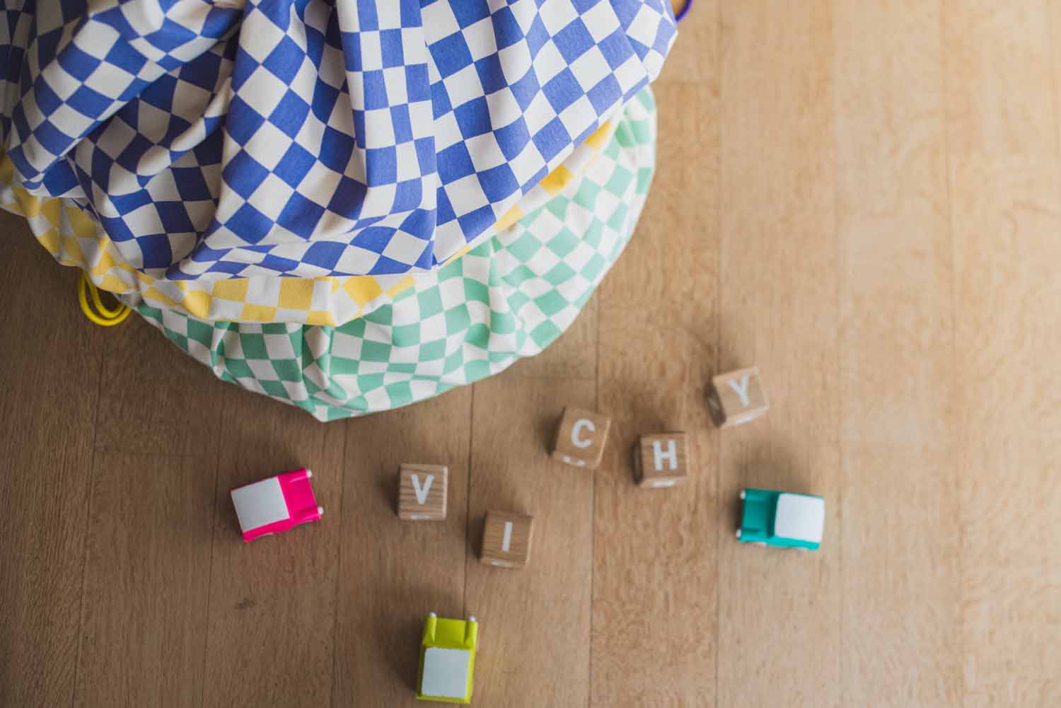 vichy toy storage bags, all colors piled on top of each other, wooden blocks and toys