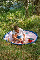 Beach outdoor storage bag, a child is sitting on the open mat in the garden, playing with a toy bridge