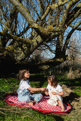 pic nic outdoor playmat, children are sitting outside, playing on the open mat in the grass under the tree