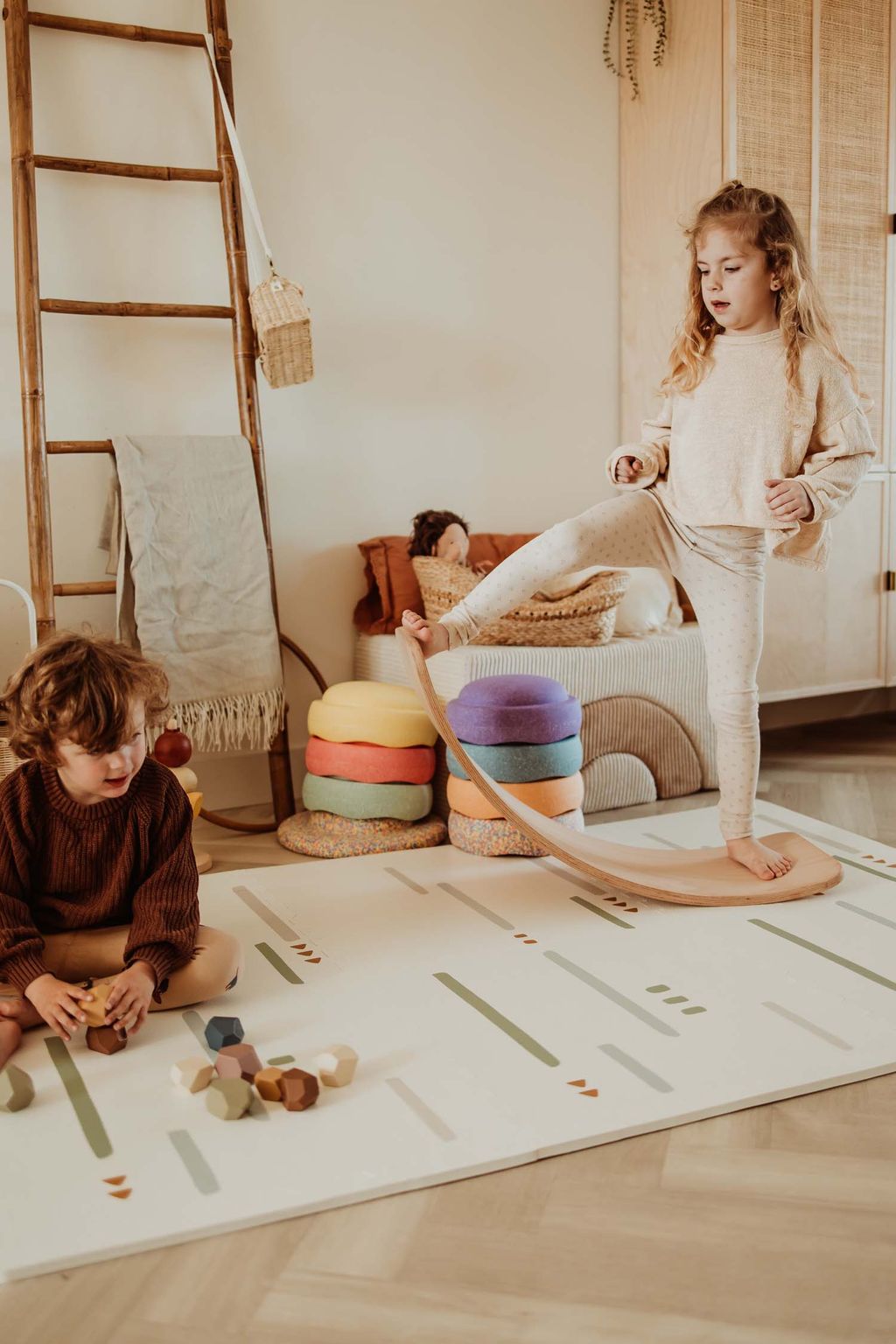 EEVAA farm puzzlemat, child is playing with wooden blocks while other child is standing on a wooden swing board in kidsroom