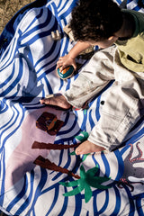 Pirate outdoor storage bag, child is playing with wooden toys on the mat in the sand