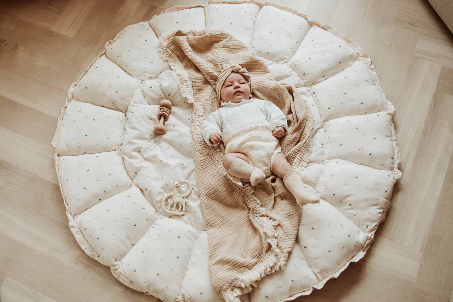 Bloom moon organic babymat, open on floor, baby sleeping on blanket on the mat