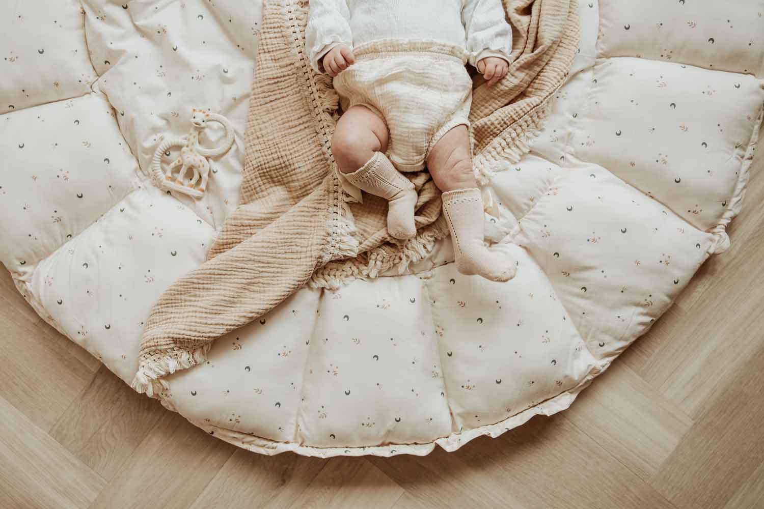 Bloom moon organic babymat, baby lying on open mat on blanket