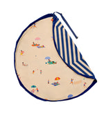 Beach outdoor storage bag with blue and white striped backside and beach scene print inside, folded piece