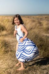 pirate outdoor playmat, young girl in a swimsuit standing in a grassy field, carrying the storage bag on its shoulders