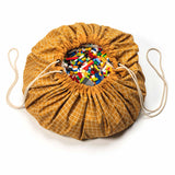 organic grid mustard storage bag, filled with toys