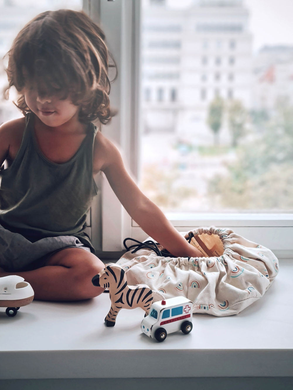 Play&Go mini storage bag, print rainbow, child playing with wooden toys sucs as zebra and medical car