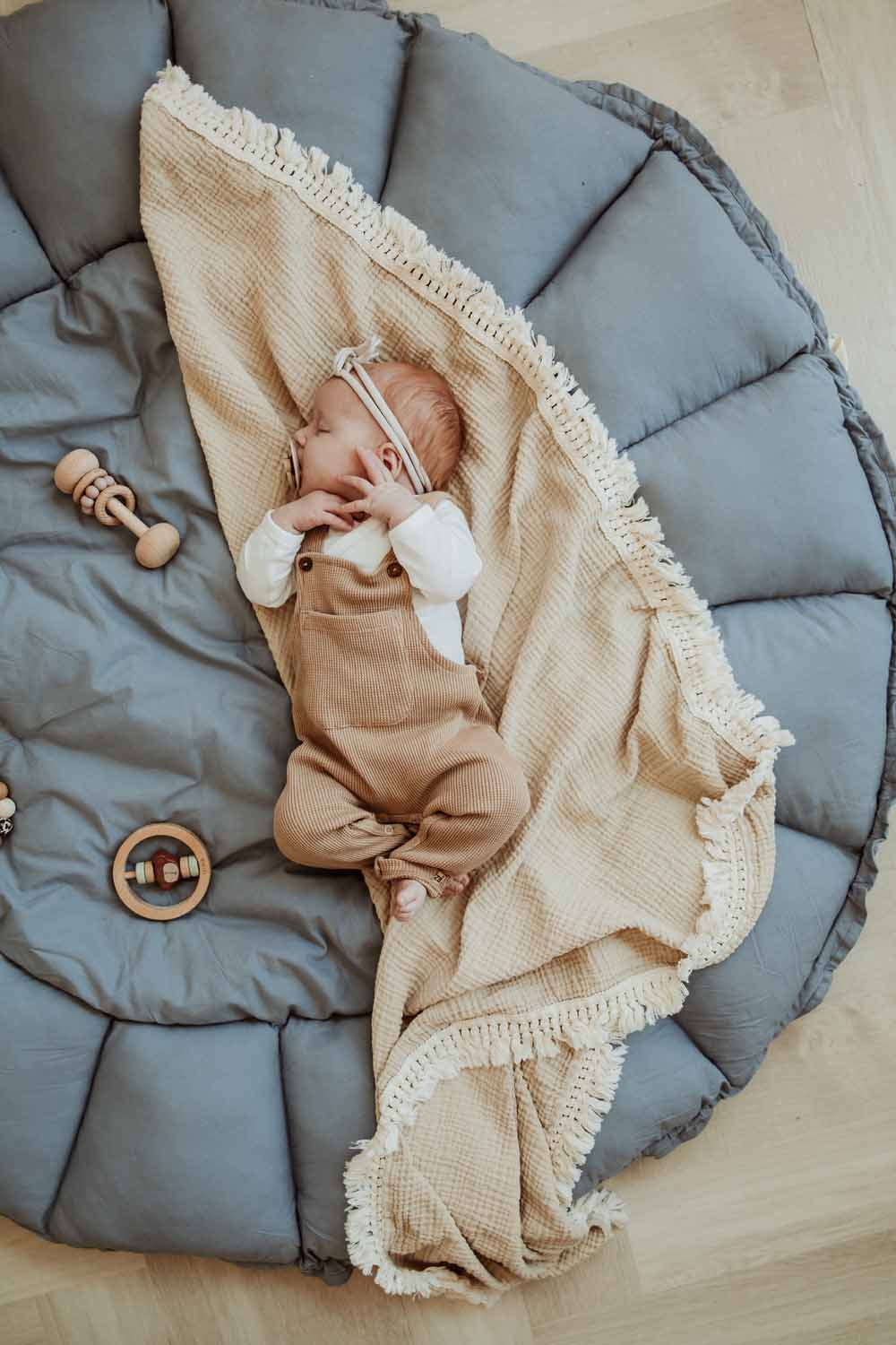 Bloom dusty blue organic babymat, open, little baby sleeping on blanket on mat
