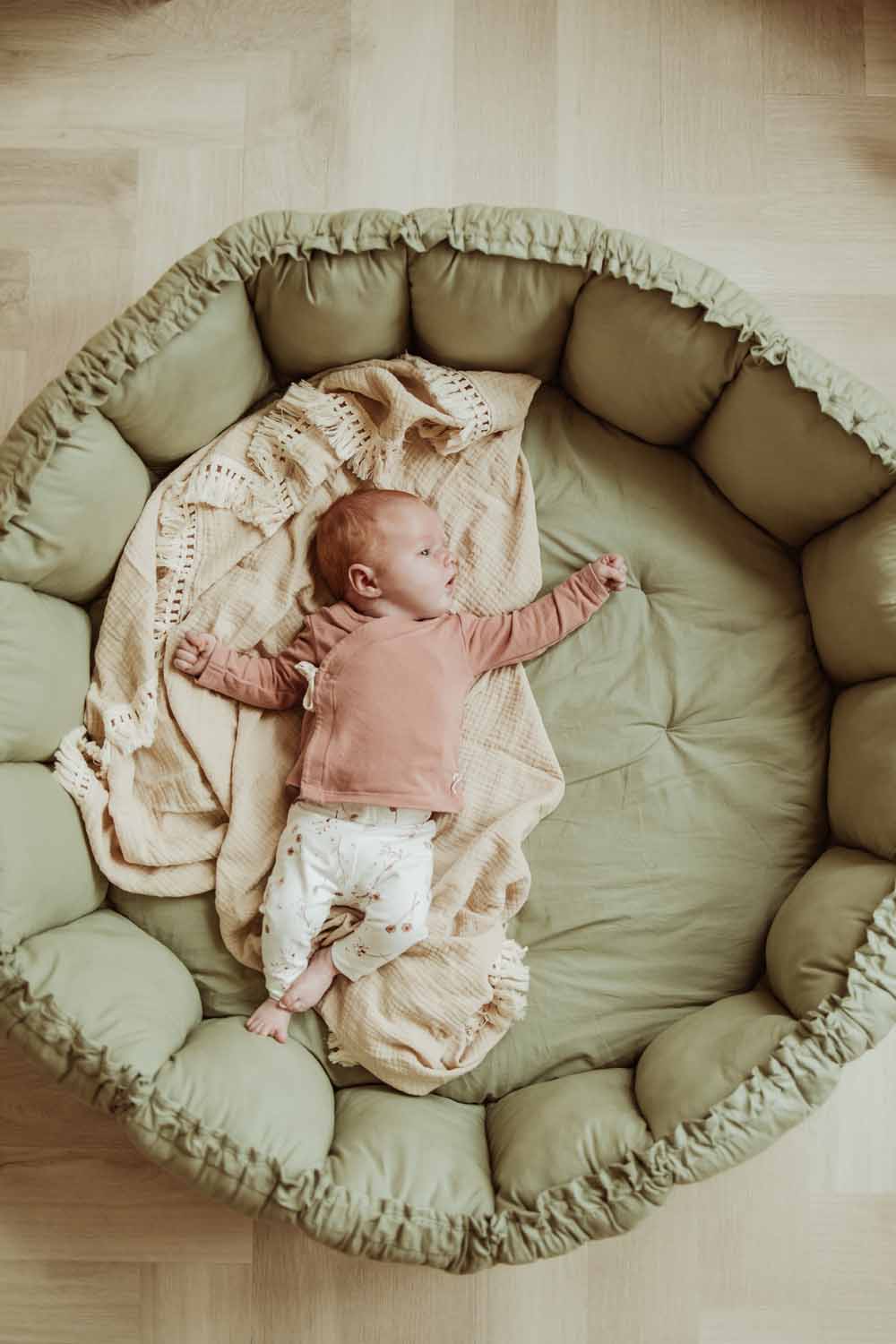 meadow green organic baby mat, little baby lying on pillow on mat