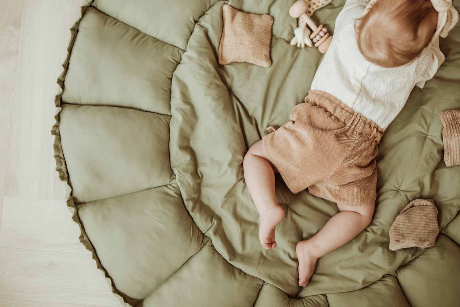 Bloom meadow green organic babymat, baby lying on open mat between toys