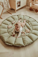 Bloom meadow green organic babymat, child lying on open mat on floor in kidsroom, next to wooden kitchen