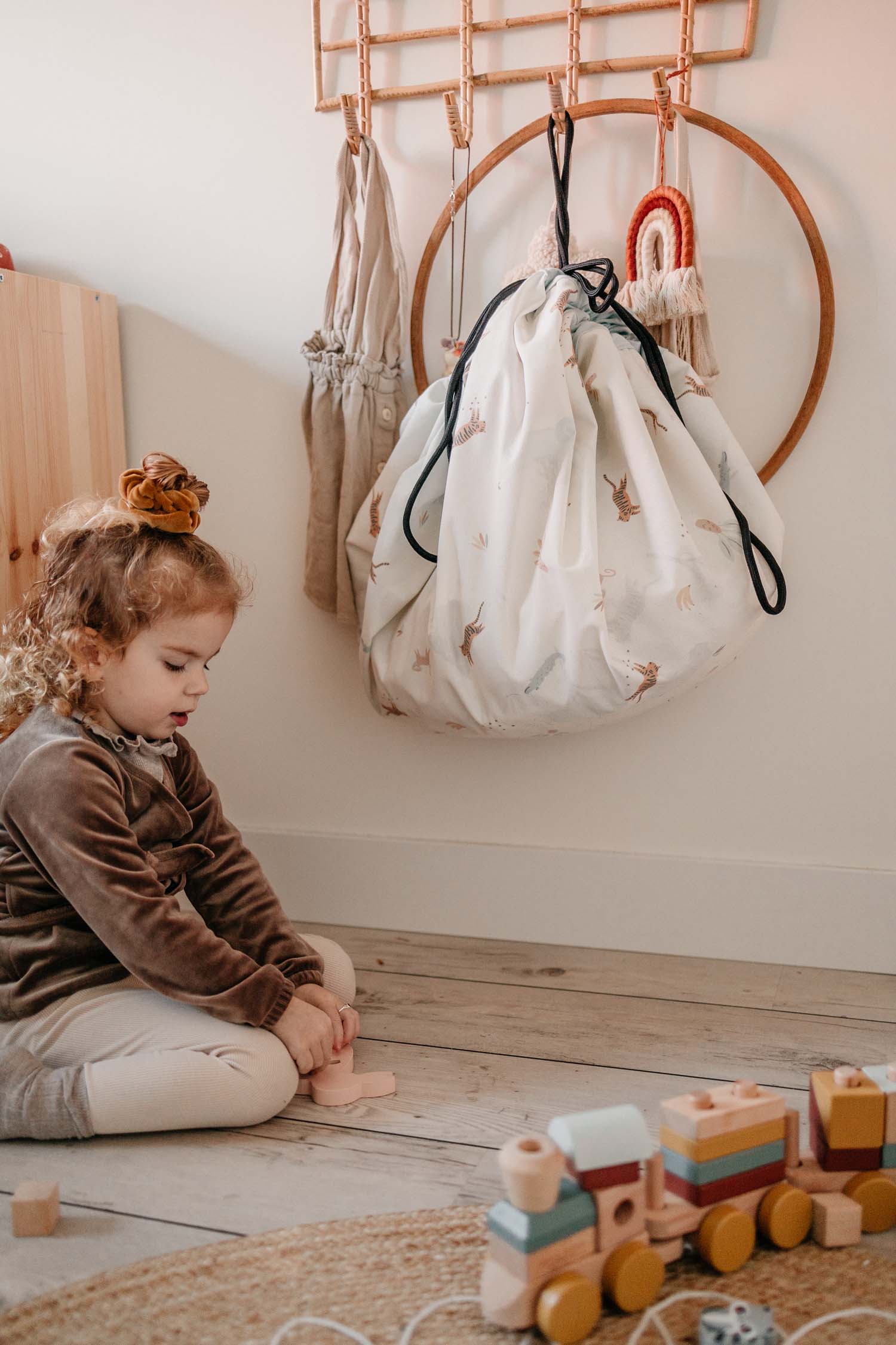 jungle toystorage bag, hanging on coat rack, child playing on floor