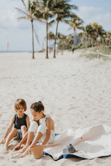 Play&Go outdoor storage bag and play mat, kids on the beach, sitting on the mat, palmtrees