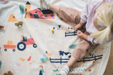 farm toy storage bag and play mat, child sitting and playing on mat with wooden toys