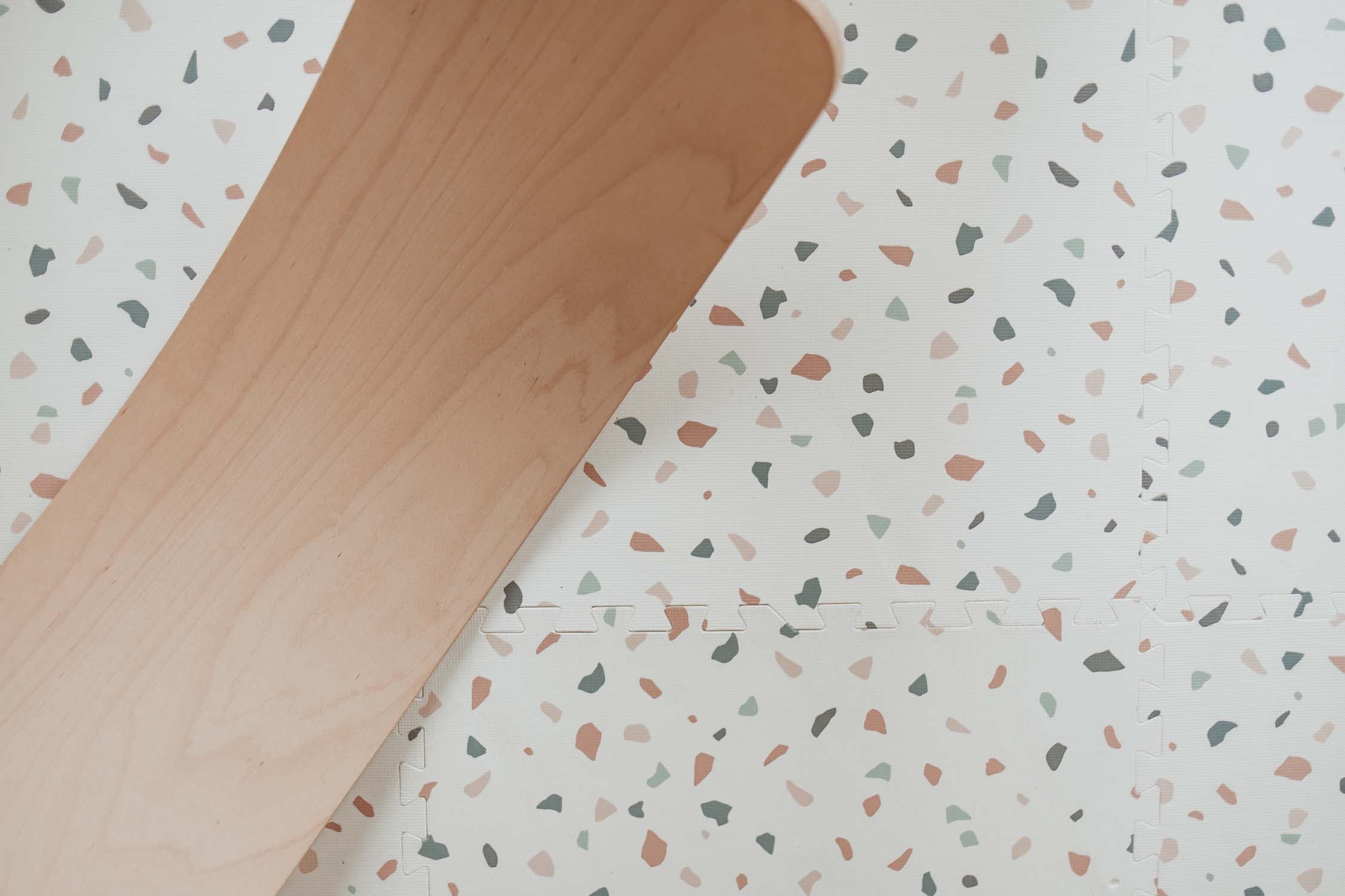 detail picture of terrazzo puzzlemat, wooden slide on top of the mat