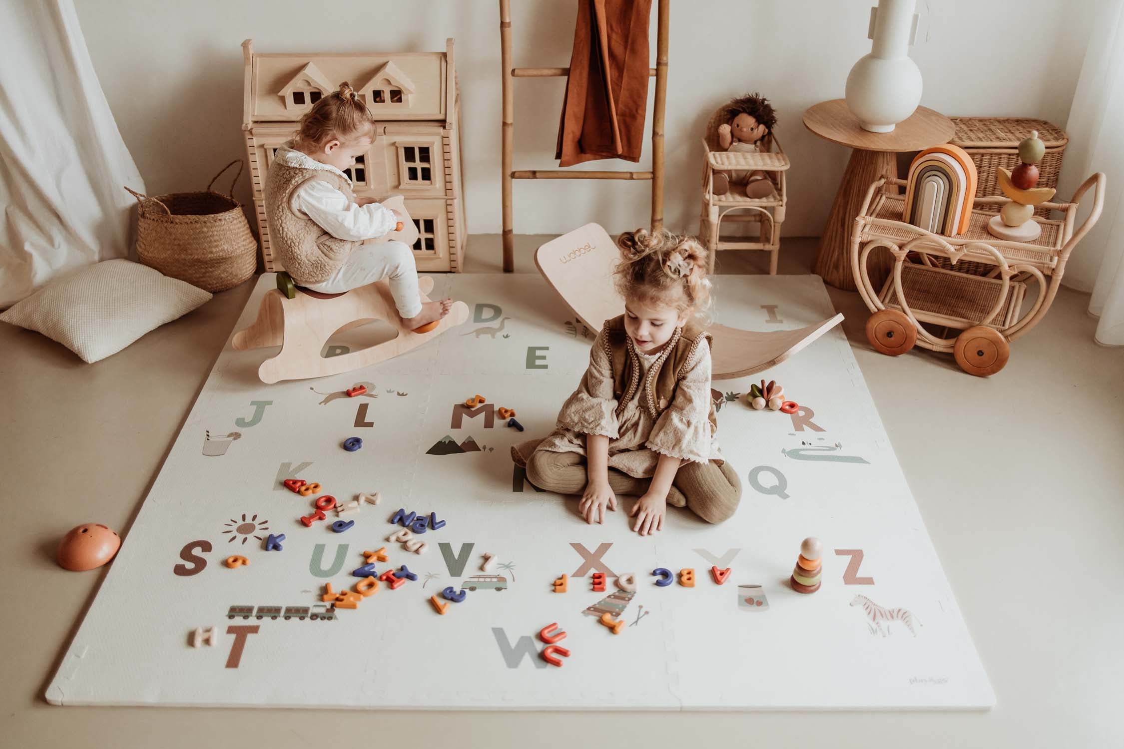 children playing with toys and rocking horse, on alphabet puzzlemat in kidsroom