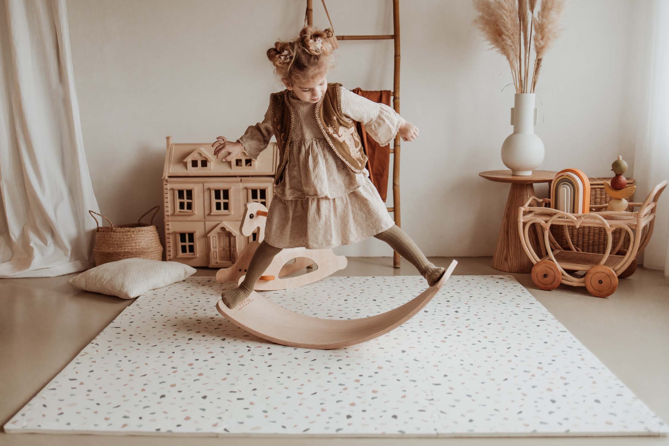 child playing with wooden slide on terrazzo puzzlemat in kidsroom
