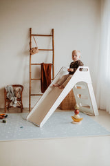 icons puzzlemat on floor, slide with child on the mat in kidsroom