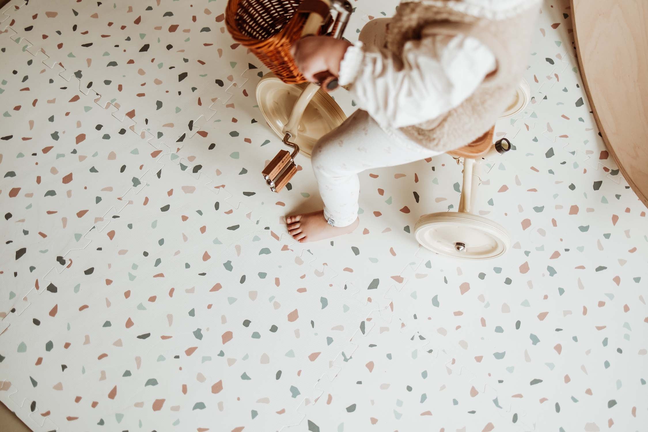 child riding with tricycle on terrazzo puzzlemat